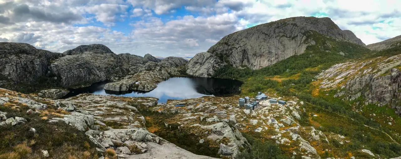 Skåpet — a cluster of small grey cabins on granite beside a mountain lake